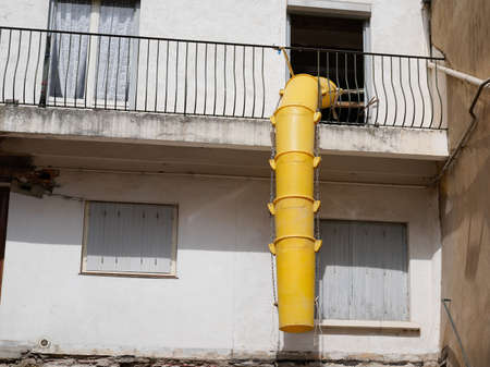 plastic slide chute for rubble debris removal on building facade renewal construction site in city...