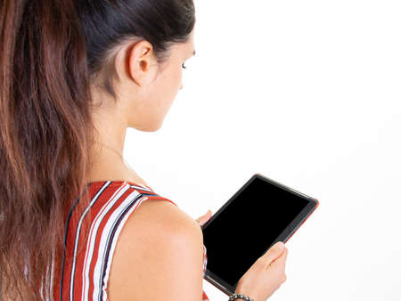 rear behind woman websurfing on digital tablet computer at white wall background home