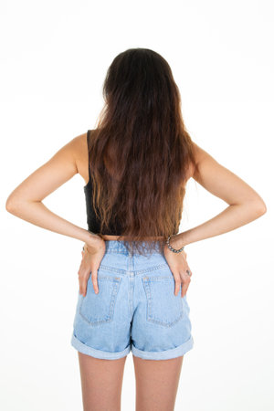 slim beautiful woman in blue short jeans behind rear back view isolated on whiteの写真素材