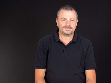 Man handsome portrait in black shirt smiling face on dark Background