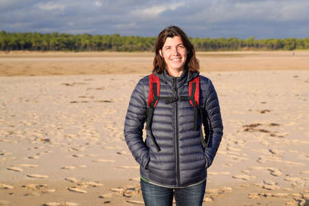 beautiful middle aged woman on sandy beach sea coast in autumn day