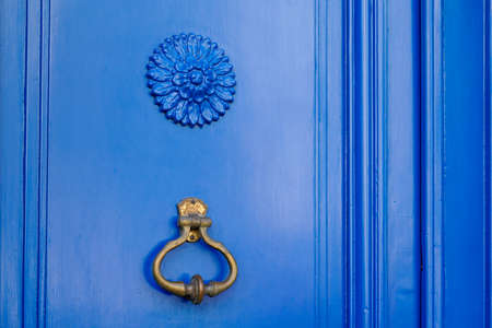 Old iron ring on vintage blue retro door for knocking on facade classic houseの写真素材
