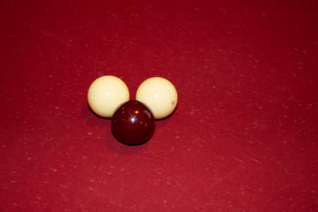 french billiard balls white and red on the burgundy slate board
