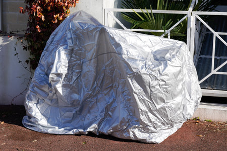 cycle street parked protected by silver protective wrap protecting cover bike and bicycle tarpaulin jacketの写真素材