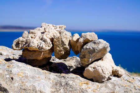 Zen outdoors stacked rocks balanced stones stack pyramid bridge with sea coast background water...
