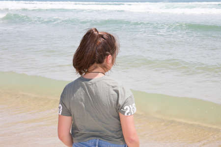 back view of teenager girl on sand beach sea summer looking relaxing wave horizon