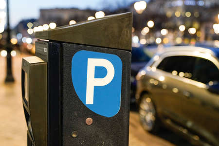 parking meter sign blue white p car parked in city street on evening night town