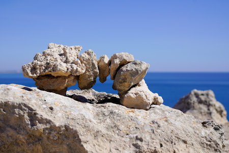 Zen stones outdoors stacked rocks balanced stone stack pyramid bridge with sea coast background water beach ocean horizonの写真素材