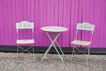 metal colorful chair seat table in summer in street front pink wooden wall