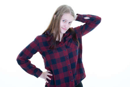 young blonde woman with one hand on the hip waist and the other behind the head dressed in a checkered hipster shirtの写真素材