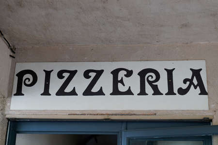 Pizzeria text sign from Italy on facade street outside entrance door restaurant italianの写真素材