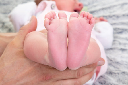 Baby feet in mother hands in Happy family maternity conceptの写真素材