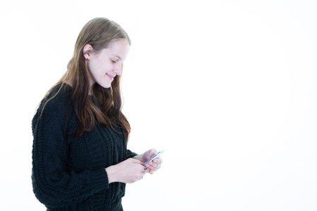 mobile apps concept with smiling beautiful woman using smartphone looking cell phone with happy face...