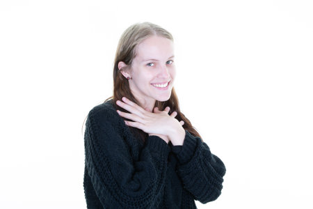 portrait of smiling blonde caucasian girl posing in studio hand on chin chestの写真素材