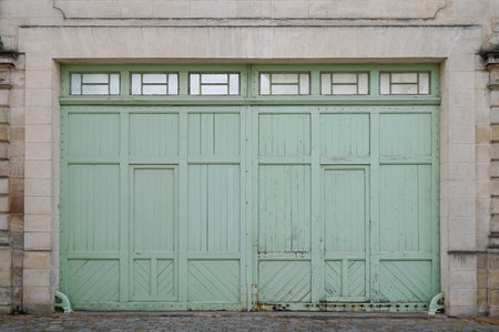 Double Wooden green ancient garage door old blue building entrance closedの写真素材