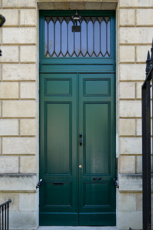 Wooden high door green on french wall entrance city street classic stone facadeの写真素材