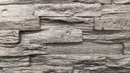 gray stone dark brick wall of gray horizontal stones facade background
