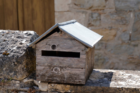 wooden dark gray classic letter box natural on old ancient stone wall fence outdoors streetの写真素材