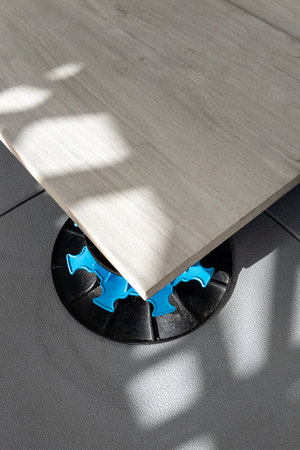Exterior plots pavement tiles installation on the house terrace with adjustable pads