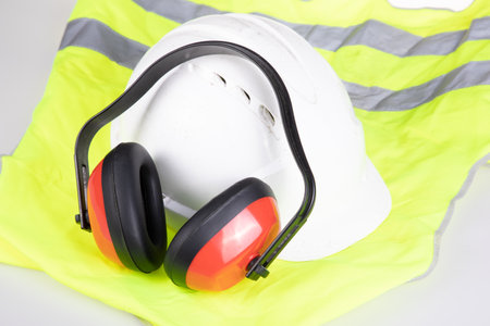 Standard flat lay safety worker protection equipment noise canceling headphones helmet and yellow reflective safety jacket vestの写真素材
