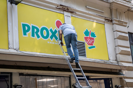 Bordeaux , France - 07 10 2023 : proxi super supermarket logo brand and text chain shop food retail with a man doing wall sign maintenance and break storeのeditorial素材