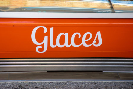 glaces text in French means ice cream on the fridge of an icecream seller with multiple flavors in...