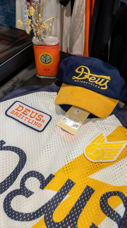 Bordeaux , France - 10 06 2023: Deus motorcycles cap and breitling shirt in store with logo brand...
