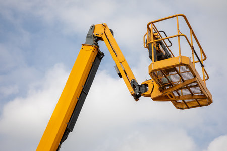 yellow industrial basket nacelle in a cloudy sky empty of marks