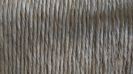 beige background of natural straw rope on spool make parallel threads of string texture