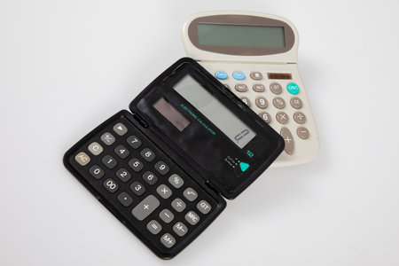 Calculator concept financial with two models with solar battery over gray white backgroundの写真素材