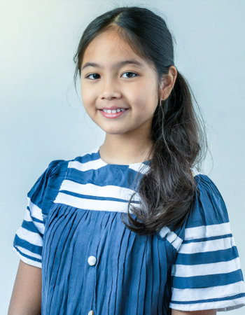 asian girl preteen long hairs posing for school photographer in gray backgroundの素材