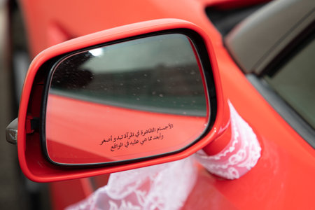 Car side mirror arabic writing text means objects in mirror are closer than they appearの写真素材