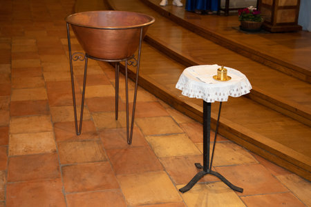 metal font in a church for the baptism of children and baptismal bowl