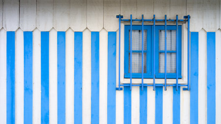 blue and white striped beach house window over stripped wall wooden summer vacation holiday backgroundの写真素材