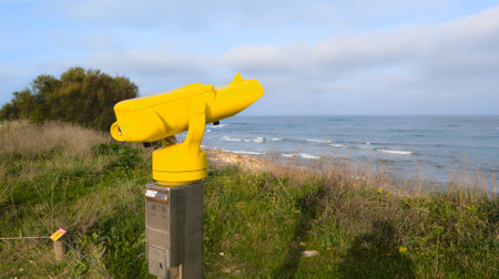 Touristic binocular yellow seaside pay to view telescope in ocean sea horizonの写真素材