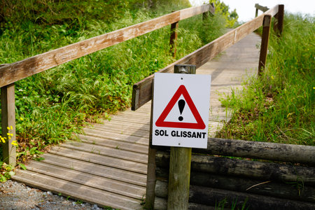 slippery floor french text road sign means slippery floor on wooden access wayの写真素材
