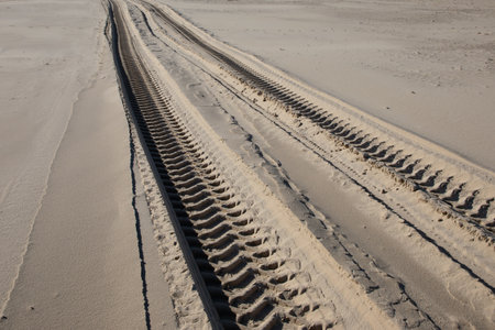 tire mark in the sand traces from tires print of machine on beach desertの写真素材