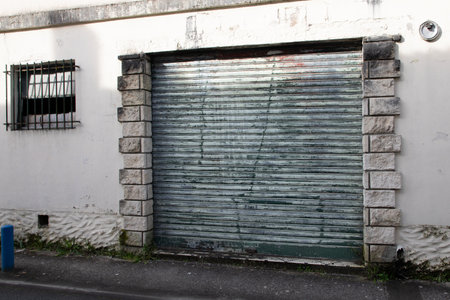 Old weathered and rusty steel door closed metal building facadeの写真素材
