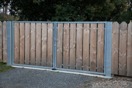 wooden door portal in facade home entrance car gate wood and steel structure access house gardenの写真素材