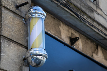 old used barber pole shop signboard cylindrical sign with light round facade hairdresser wallの写真素材