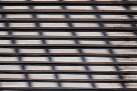 texture of wooden blinds shutters background with sun shadows