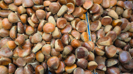 background close up of a pile of chestnuts on the market of a pile of chestnutの写真素材