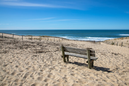 wooden empty bench alone on coast beach front atlantic ocean seaside arcachon bay seaの写真素材