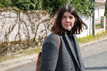 portrait of middle aged 40 year old brunette woman walking in city streetの写真素材