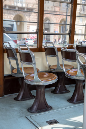 empty wooden and aluminum seats line in ancient restored old tram italian tourist tramwayの写真素材