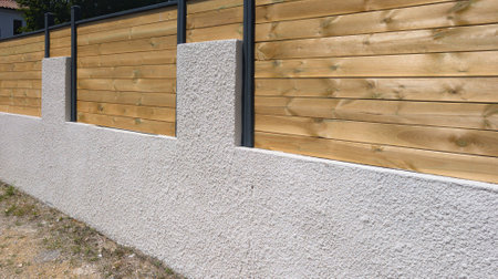 wall cinder block wall and wooden fence with structure street wood barrier private house protect view and access home gardenの写真素材