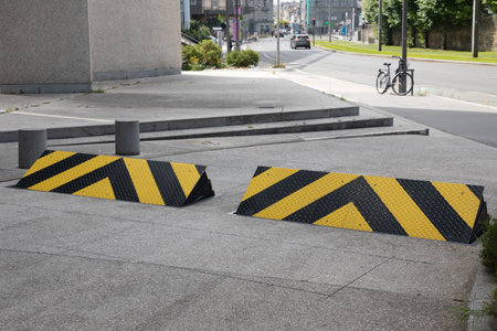 car retractable roadblock obstacle entering the ground and rising against vehicles trying to enter a site yellow road signの写真素材