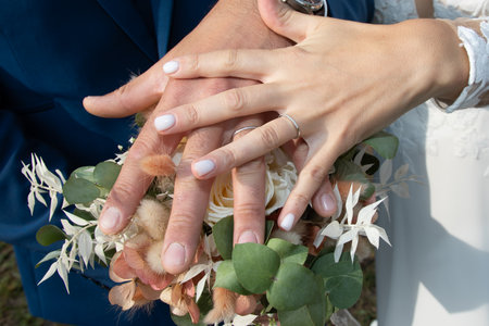 wedding day rings fingers couple and hands bride and groom in love on flower bouquetの写真素材