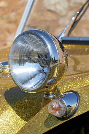 chrome front car headlight on the hood of a dune buggy in glittery gold color kit carの写真素材