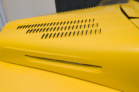 hood louvers front close up of a yellow custom car hotrod detailの写真素材